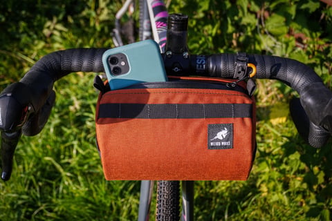 Wizard Works Lil Presto handlebar bag in orange on drop bars, with a phone tucked into the top pocket.
