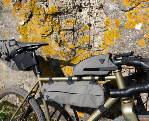 Topeak Bikepacking Series saddle, frame and top tube bags in green on a Bombtrack gravel bike, close up.