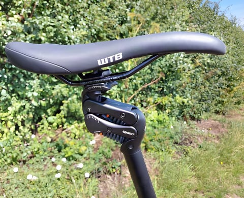 Cirrus Cycles Kinekt 2.1 suspension seatpost with its pivoting linkage and coil springs beneath a WTB saddle.