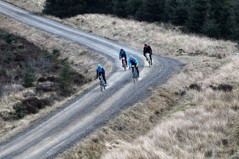 Dirty Reiver riders on a gravel forest road across open moorland, an event run by Focal Events.