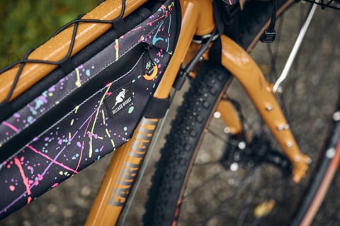 Wizard Works frame bag label and splatter fabric beside the Fairlight name on the Faran's mustard downtube.