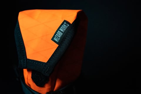 Fluro orange Wiz Viz Teeny Houdini pouch with a Wizard Works woven label and black binding.