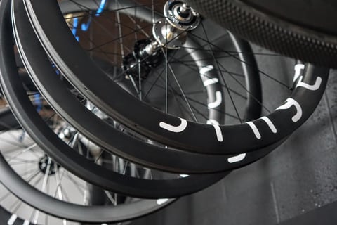 Stack of black carbon gravel rims with white Stayer lettering, ready for wheelbuilding.