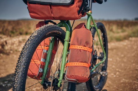 Road Runner Buoy Bags with orange straps in King Cage fork cages either side of the Faran's Continental front tyre.