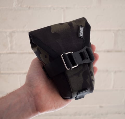 Medium Teeny Houdini in black camo, with buckled strap and a loop at the base.