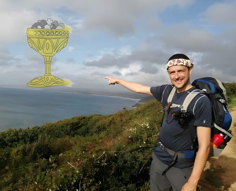 Hiker with a rucksack points at a cartoon golden grail of gravel drawn over a coastal path, for the geologist's gravel guide.