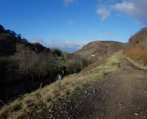 Gravel bike parked beside a rough track in a South Wales valley, wind turbine on the hill, on Nic's Festive 500.