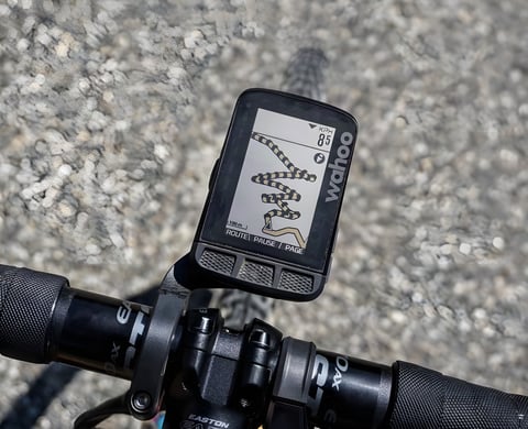 Wahoo ELEMNT ROAM showing a route map on a bike's out-front mount, with coarse gravel below.
