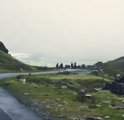 Cyclists on a road winding through misty green Welsh hills, a frame from The Friction Collective's film Velo Wales.