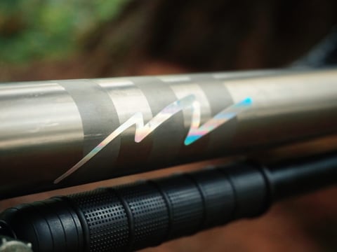 Close-up of the iridescent lightning-bolt decal on the Planet X Tempest top tube, above the Zefal frame pump.