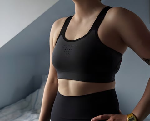 Velocio LUXE sports bra in dark grey, front view with the grid of small ventilation holes on the upper chest.