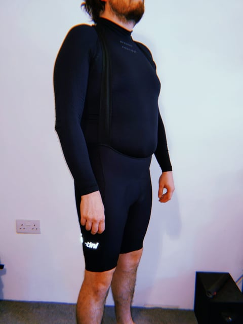 Rider wearing the Santini Gravel Bib cargo shorts over a black base layer, front view, with a reflective logo on the thigh.