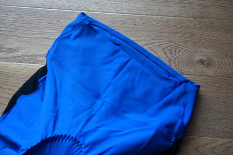 Back of the blue Foundations liner shorts laid flat, with the hidden waistband pocket slit and a black mesh side panel.