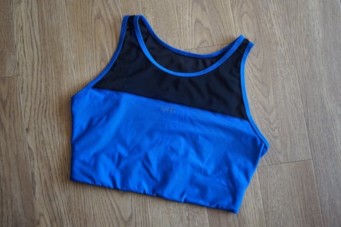 Machines For Freedom Foundations Sports Bra in blue with a black mesh upper panel, front view.