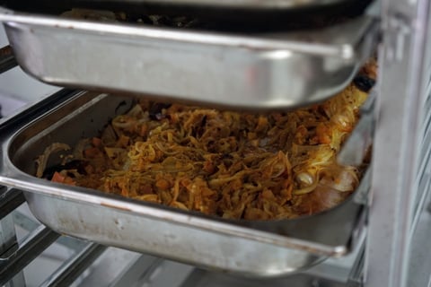 Cooked meal mix spread thinly in a steel tray on a rack, ready for Firepot Food's air-drying chambers.