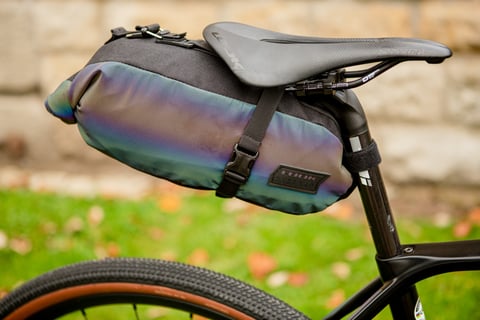 Look and Restrap iridescent saddlebag strapped under a Look saddle, with the Restrap label on its side.