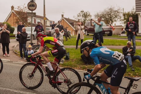 CAMS-Basso and Movistar riders race past cheering spectators on stage 4 of the Women's Tour of Britain.