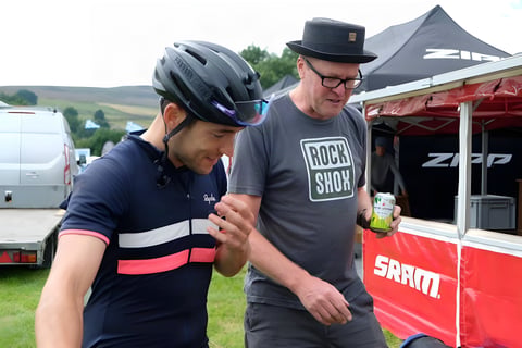 Chris Hinds chats with a man in a RockShox T-shirt beside SRAM and Zipp tents at a Great British Divide stop.
