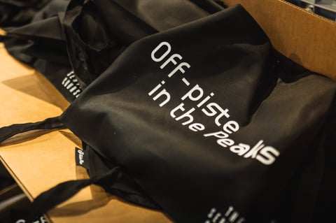 Black tote bag printed Off-piste in the Peaks, part of the Service Course Gravel Bonanza rider goodies.