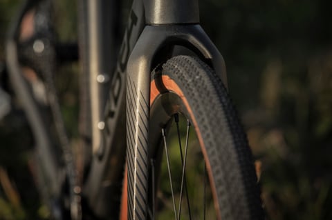Orbea Terra carbon fork and front gravel tyre with tan sidewall, shown close up.