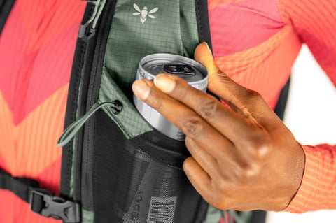 A drinks can slotted into the front stretch pocket of the Apidura Racing Hydration Vest.