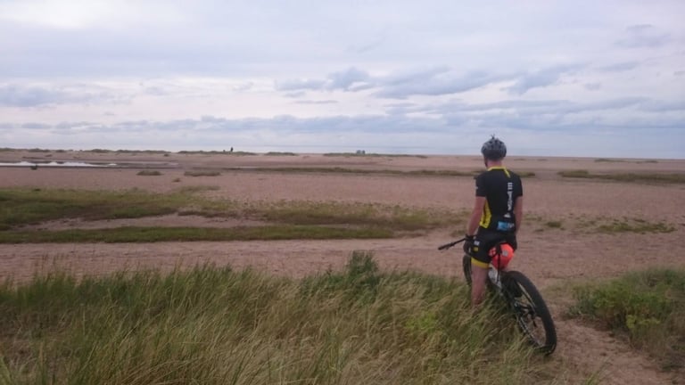 Rider pauses on the Surly Krampus to look across marsh to the sea at Holme-next-the-Sea, the end of the Peddars Way.