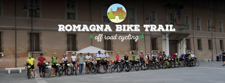 Romagna Bike Trail logo over a line of bikepacking riders and their bikes gathered in a town square.