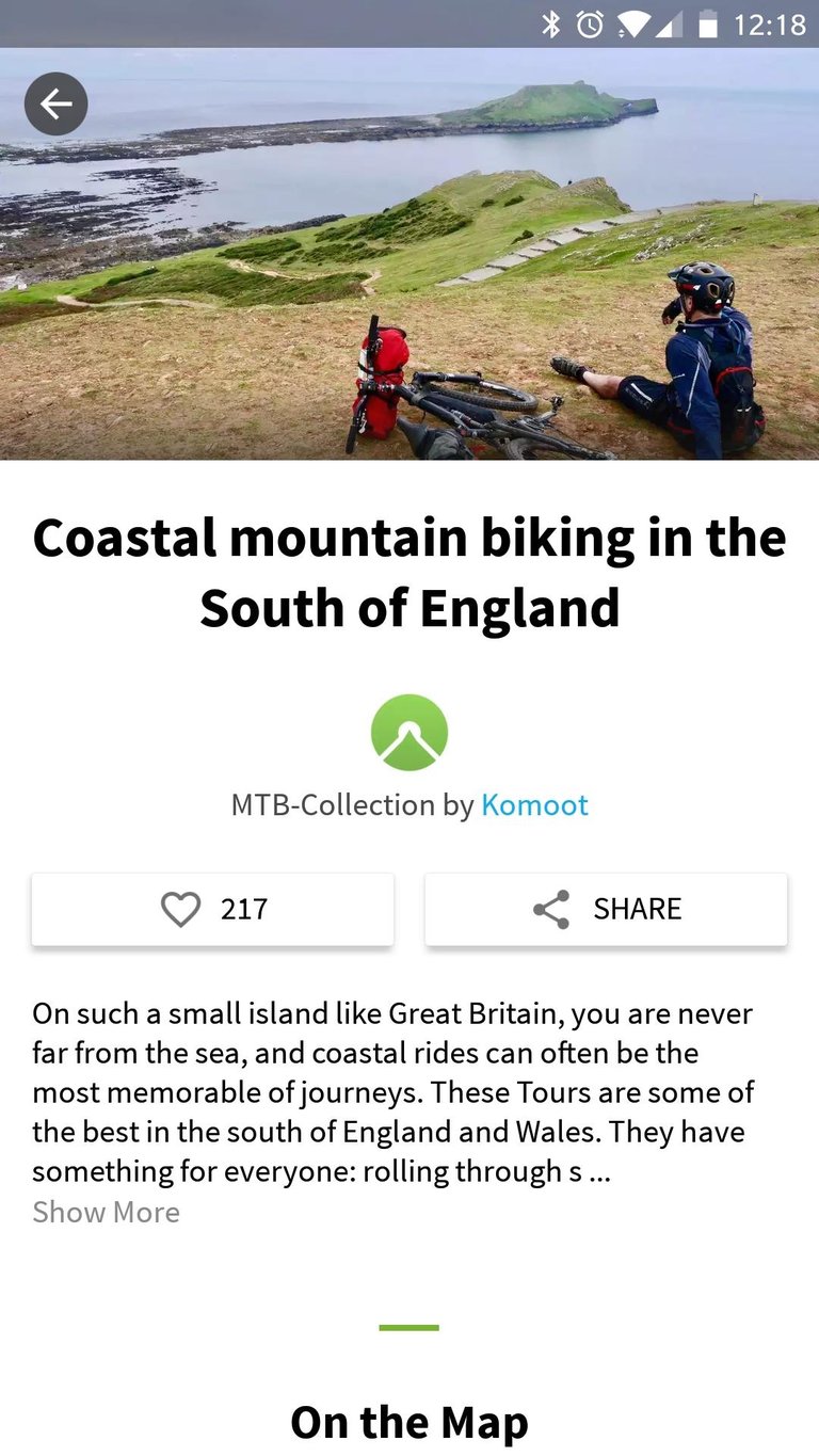 Komoot Collection screen for coastal mountain biking in the South of England, with a rider resting beside a bike.