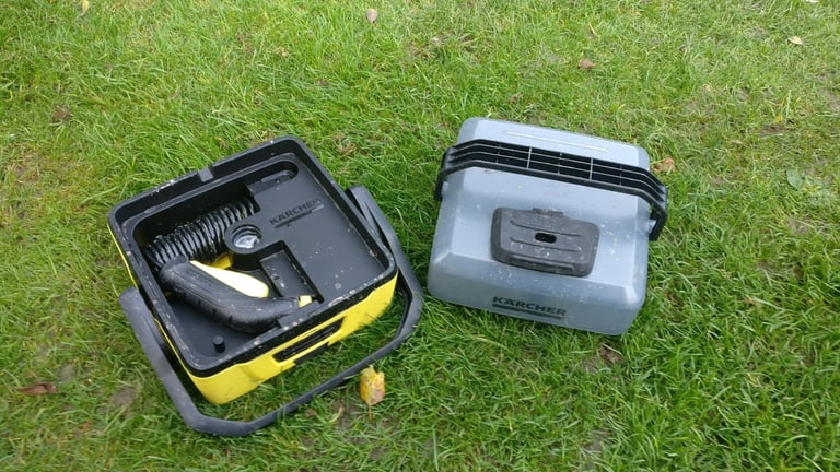 Kärcher OC3 portable washer with the water container detached, showing the hose and spray gun stored in the base.