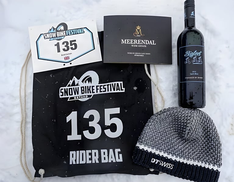 Snow Bike Festival Gstaad rider bag number 135 with a DT Swiss hat, race number and bottle of Bigfeet wine.