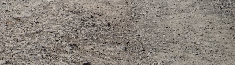 Close view of a loose, stony gravel road surface.
