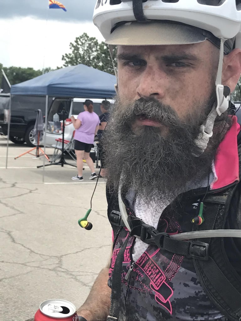 Selfie of a weary David Markman in helmet and hydration pack, cola can in hand, late in the Dirty Kanza 200.