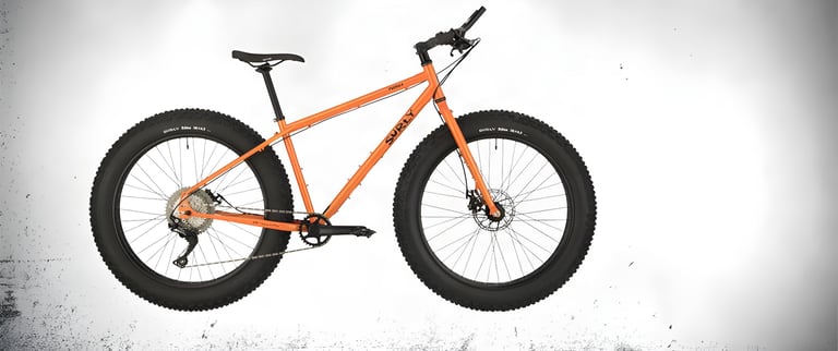 Surly Pugsley V2.0 in orange, side view, with fat tyres and a Shimano SLX 1x11 drivetrain.