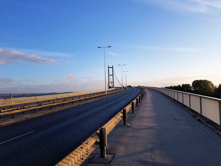 Cycle path beside the carriageway on a long suspension bridge at sunrise on the London-Edinburgh-London route.