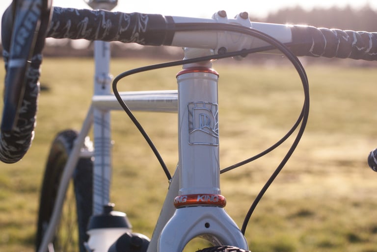 Close-up of the Donard x Victory Chimp head tube with Donard headbadge, Chris King headset and black camo bar tape.