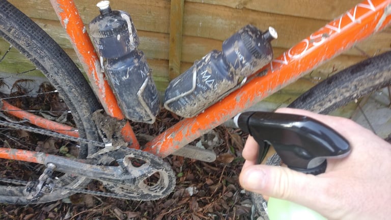 Mud-caked orange gravel bike frame, bottles and chainset ready to be sprayed with Guy Martin's Proper Cleaner.
