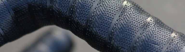 Close-up of Lizard Skins DSP 3.2mm bar tape wrapped on a drop bar, showing the grippy embossed texture.