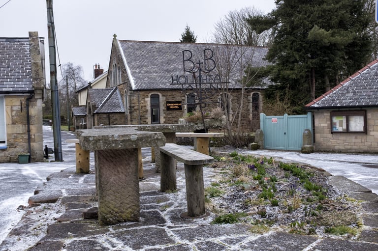 Greenhead Hostel with its B&amp;B sign behind frosted stone picnic tables, the Friday night base for the Dirty Reiver recce.