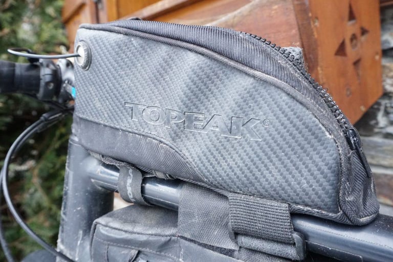 Side panel of the Topeak Fuel Tank, with its embossed Topeak logo and carbon-look finish.