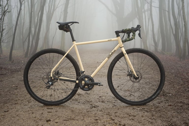 Fearless Vulture in Quicksand with a 2x Shimano Ultegra crankset and big tyres on a muddy track through misty woodland.
