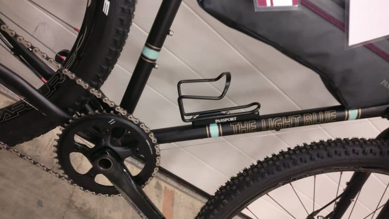 Passport Cage Mover fitted under the bottle cage on the down tube of the Light Blue Darwin One By MT.
