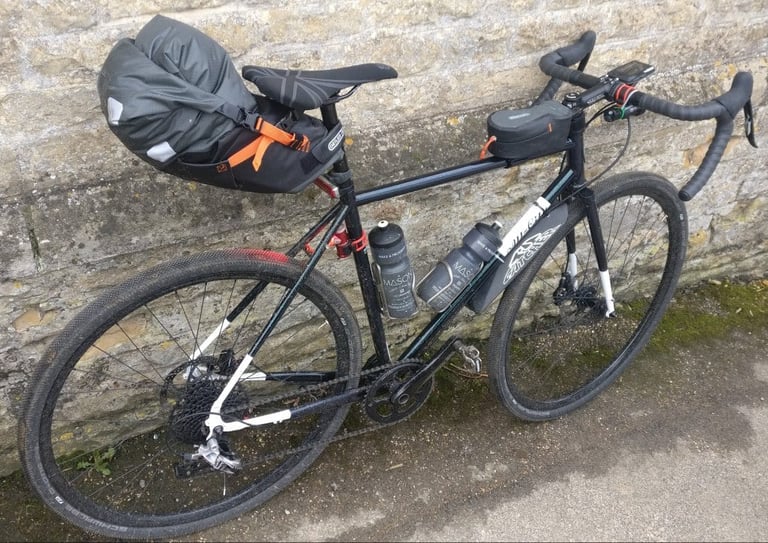 Ortlieb Cockpit Pack and Medium Saddle Pack fitted to a Mason Bokeh gravel bike leant against a stone wall.