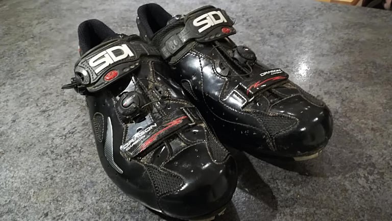 Pair of black Sidi Dragon 4 Mega MTB shoes with twin dials and a toe strap, seen from the front.