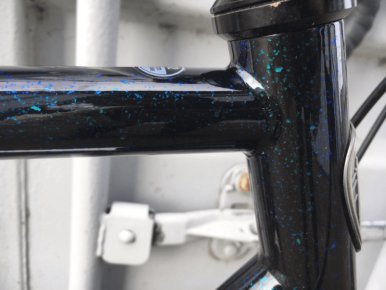 Close-up of the blue and green metal flake paint on the All-City Macho Man's head tube and top tube.