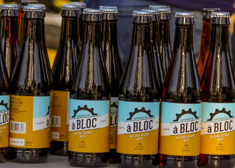 Rows of à Bloc natural blonde beer bottles lined up on a table, the finish-line drink waiting for Dirty Reiver riders.