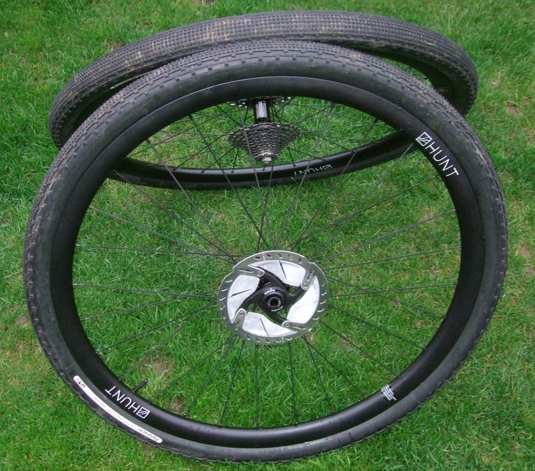 Pair of Hunt 30 Carbon Gravel wheels with Panaracer gravel tyres fitted, lying on a lawn.