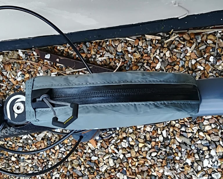 Apidura top tube bag fitted to a bike frame, seen from above, with its zip and large finger puller.