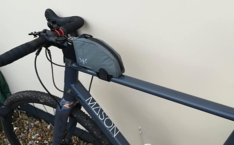 Apidura Backcountry Top Tube Bag on a grey Mason Bokeh, angled view showing the velcro strap round the top tube.