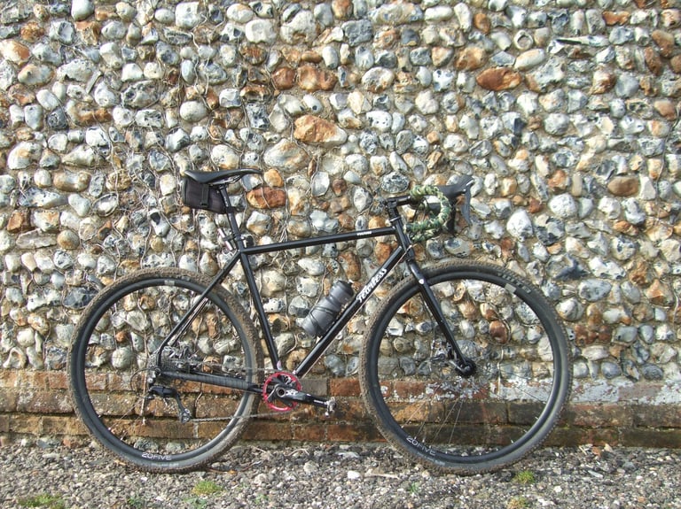 Fearless Vulture review bike in black, side-on against a flint and brick wall, with Hope 20Five rims and WTB tyres.