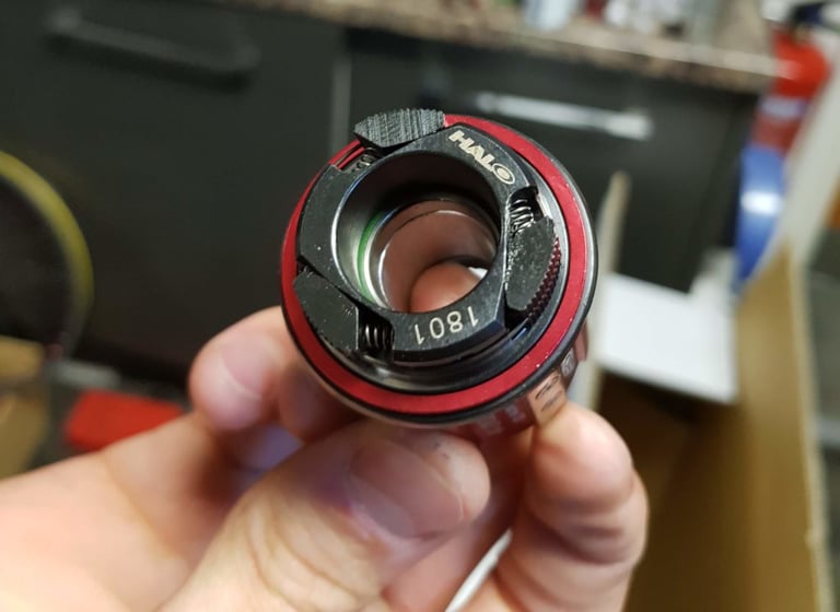Halo GXC Supadrive freehub body held in a hand, showing the sprung pawls and Halo logo.